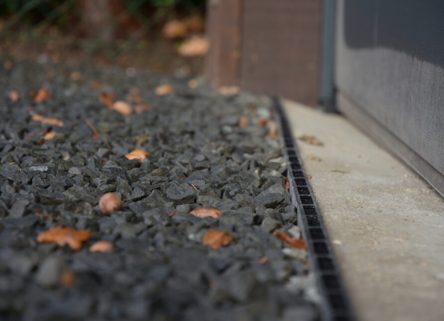 Close-up of completed gravel driveway using Gravelrings, in front of garage door