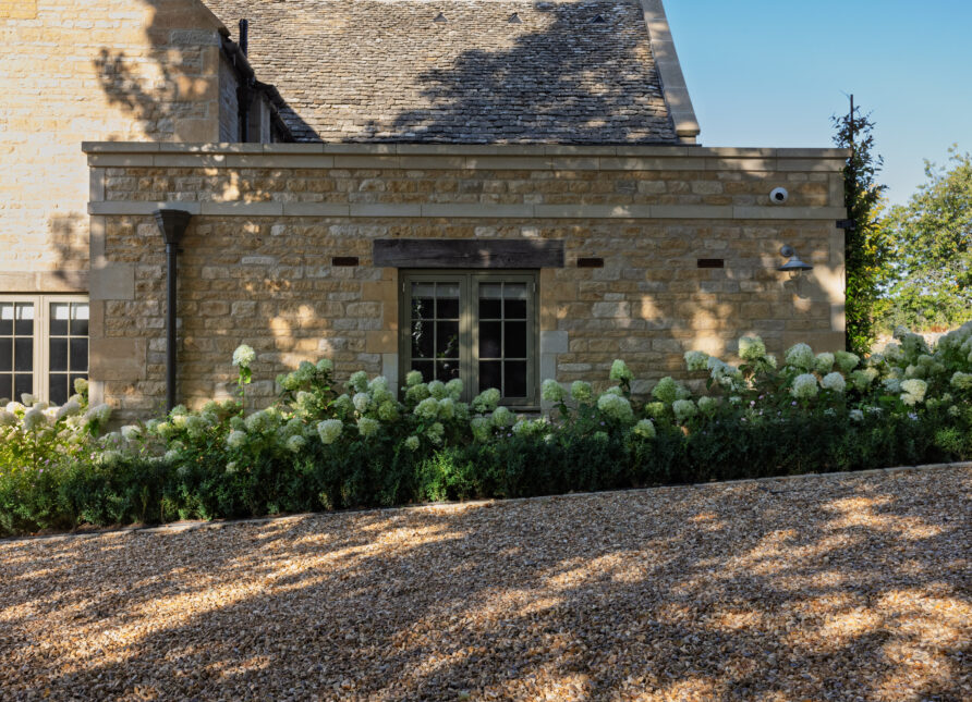 Sloping gravel driveway with gravel retention system at a UK home